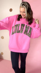 Close-up of the pink Lulu Mac sweatshirt showing arched camouflage lettering, dropped shoulders, and ribbed cuffs.