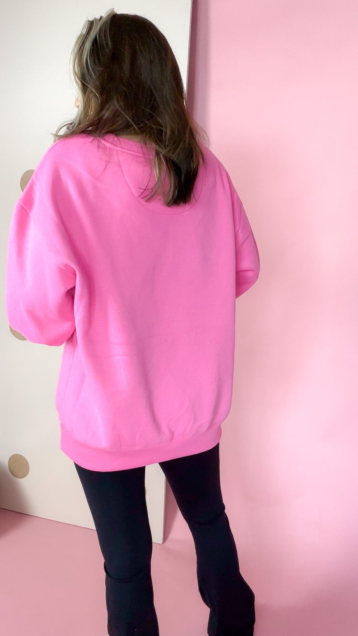 Back view of the bubblegum pink Lulu Mac sweatshirt showing its plain back and ribbed hem.