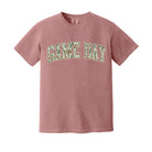 A dusty rose short-sleeve t-shirt with 'GAME DAY' printed across the chest in arched varsity letters filled with a green camouflage pattern, shown on a plain white background.