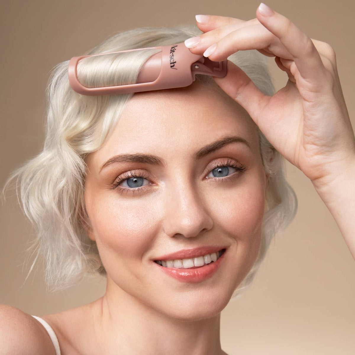 Model placing a terracotta Kitsch Hair Volumizing Clip at her roots for lift
