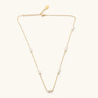 Marina pearl necklace with freshwater pearl clusters along a fine gold-tone chain and extender on a light background.