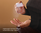 Touchland Spiced Pumpkin-Tini Power Mist being sprayed onto a hand, dark coat