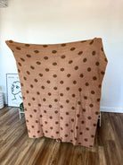 Reversible blanket with a light brown and dark brown polka dot pattern.
