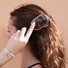 Woman brushing wavy hair with the Teleties Mini Boar Brush in tortoise