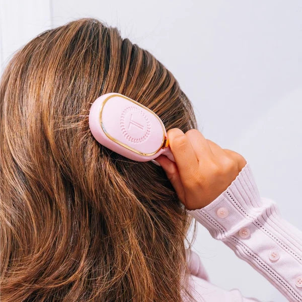Woman brushing her hair with the Teleties Mini Detangler Brush in Bubblegum Pink