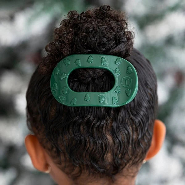 Teleties O Christmas Tree Small Flat Round Hair Clip in green holding a curly bun