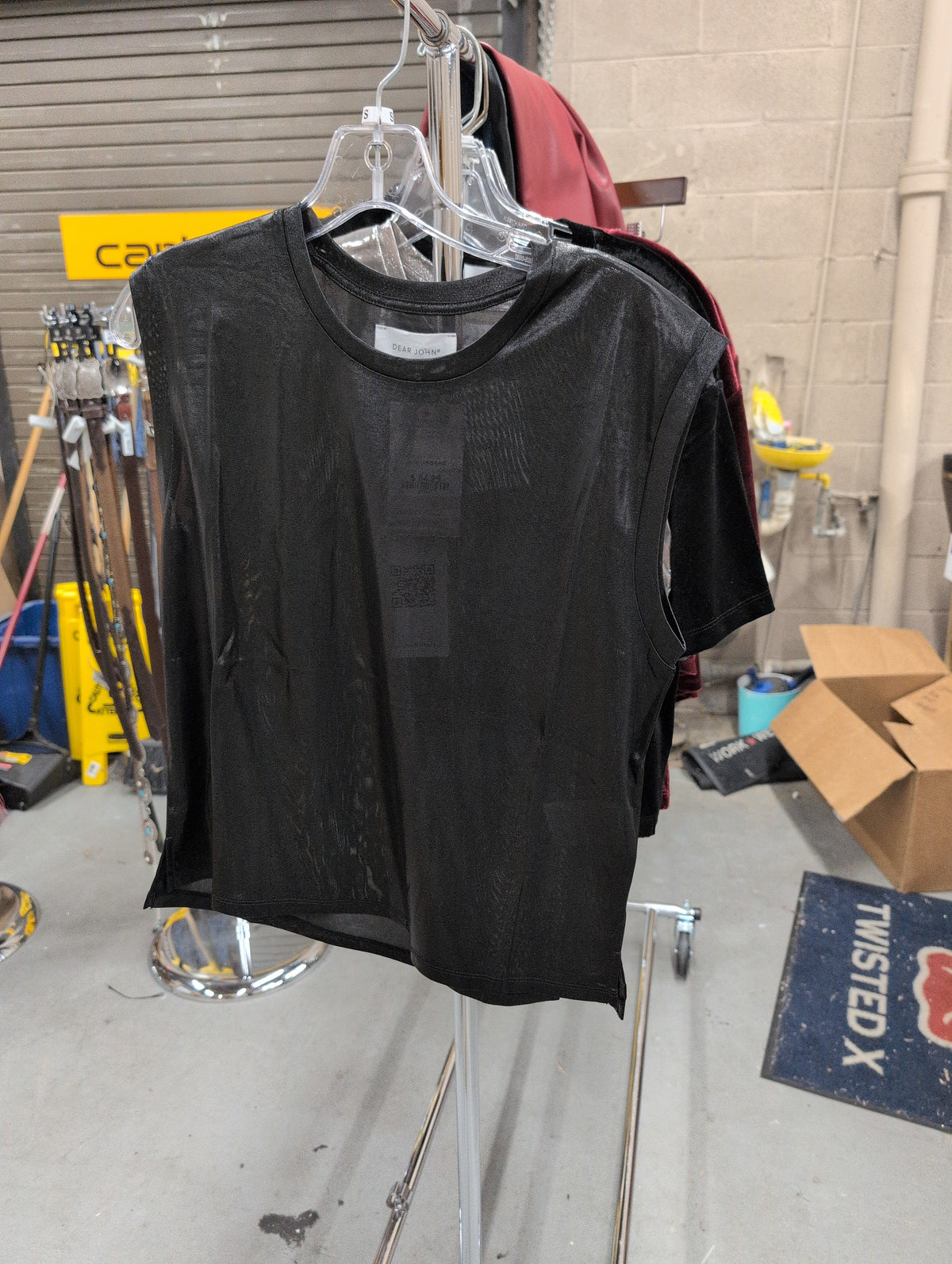 Dear John Charli Onyx Ore top on a hanger, showing the dark metallic-look finish and round neckline.