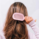 Woman brushing long hair with the Teleties Vented Brush in Bubblegum Pink