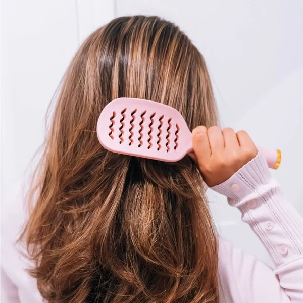 Woman brushing long hair with the Teleties Vented Brush in Bubblegum Pink