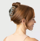 Kitsch octopus claw clip in sage green holding an updo, side view on a model